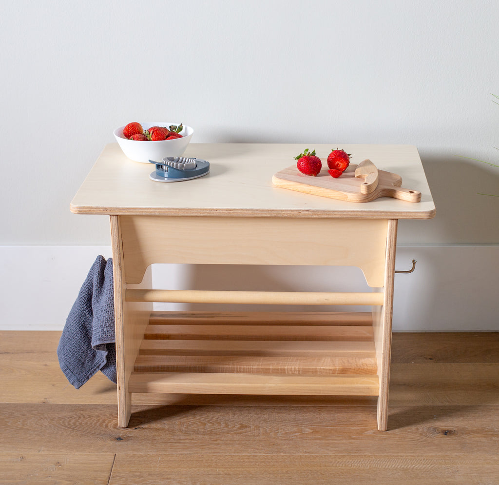 Practical Life table in a studio setting with strawberries on a cutting board