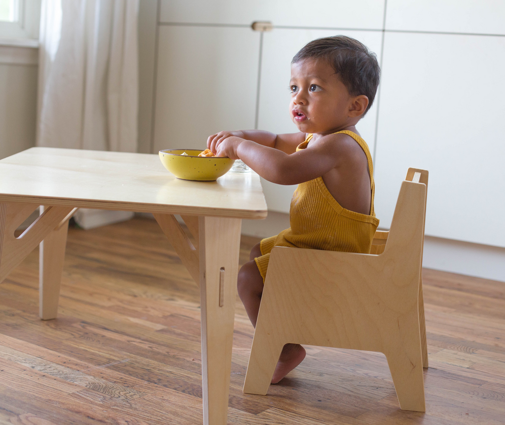 Young boy sitting at a toddler table and chair